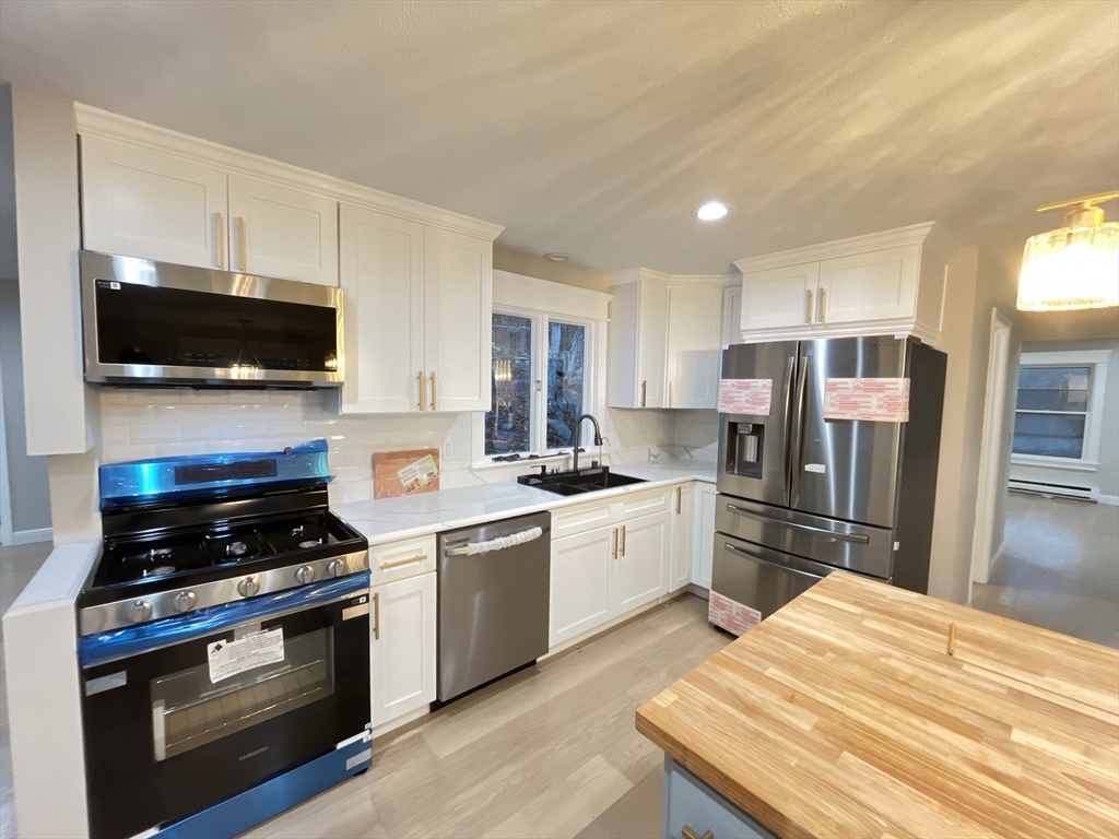 33 Highview Road Rockport, MA 01966 - Photo 21 of 31 a kitchen with stainless steel appliances kitchen island granite countertop a stove refrigerator and microwave