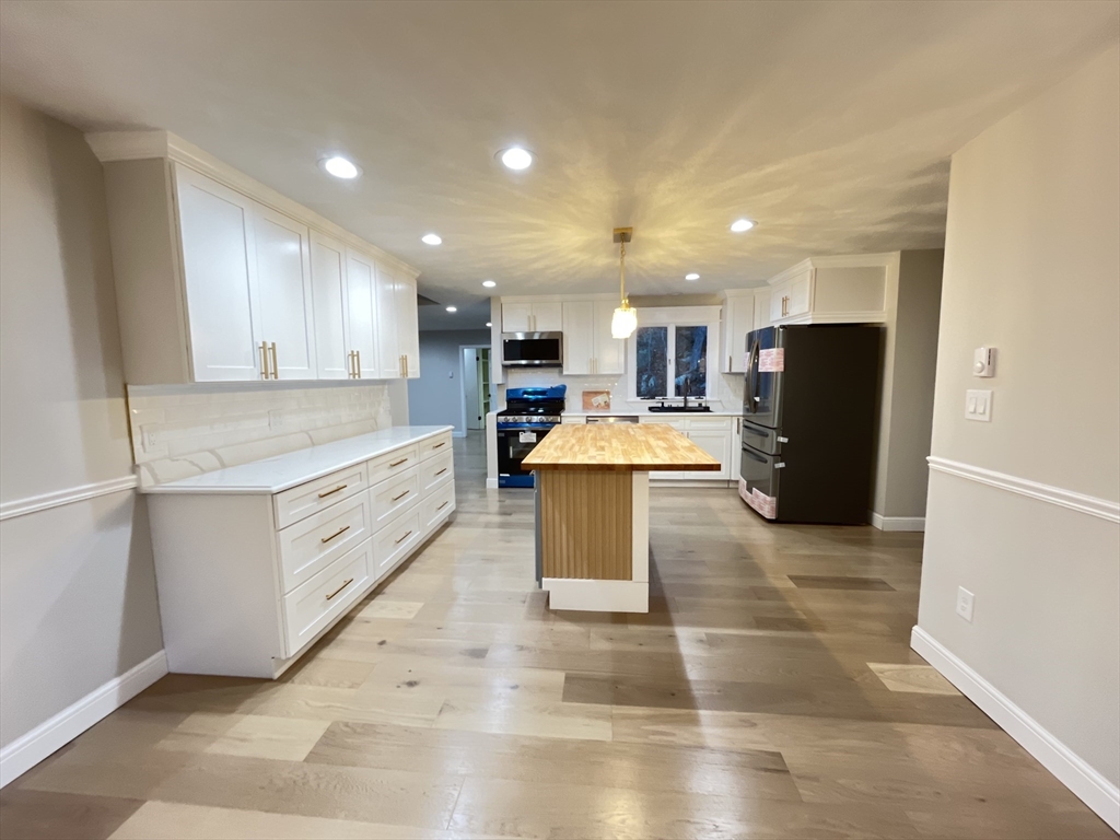 33 Highview Road Rockport, MA 01966 - Photo 25 of 31 a large white kitchen with kitchen island a stove a refrigerator a sink and a counter top space