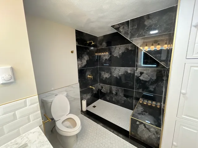 a bathroom with a toilet and a shower