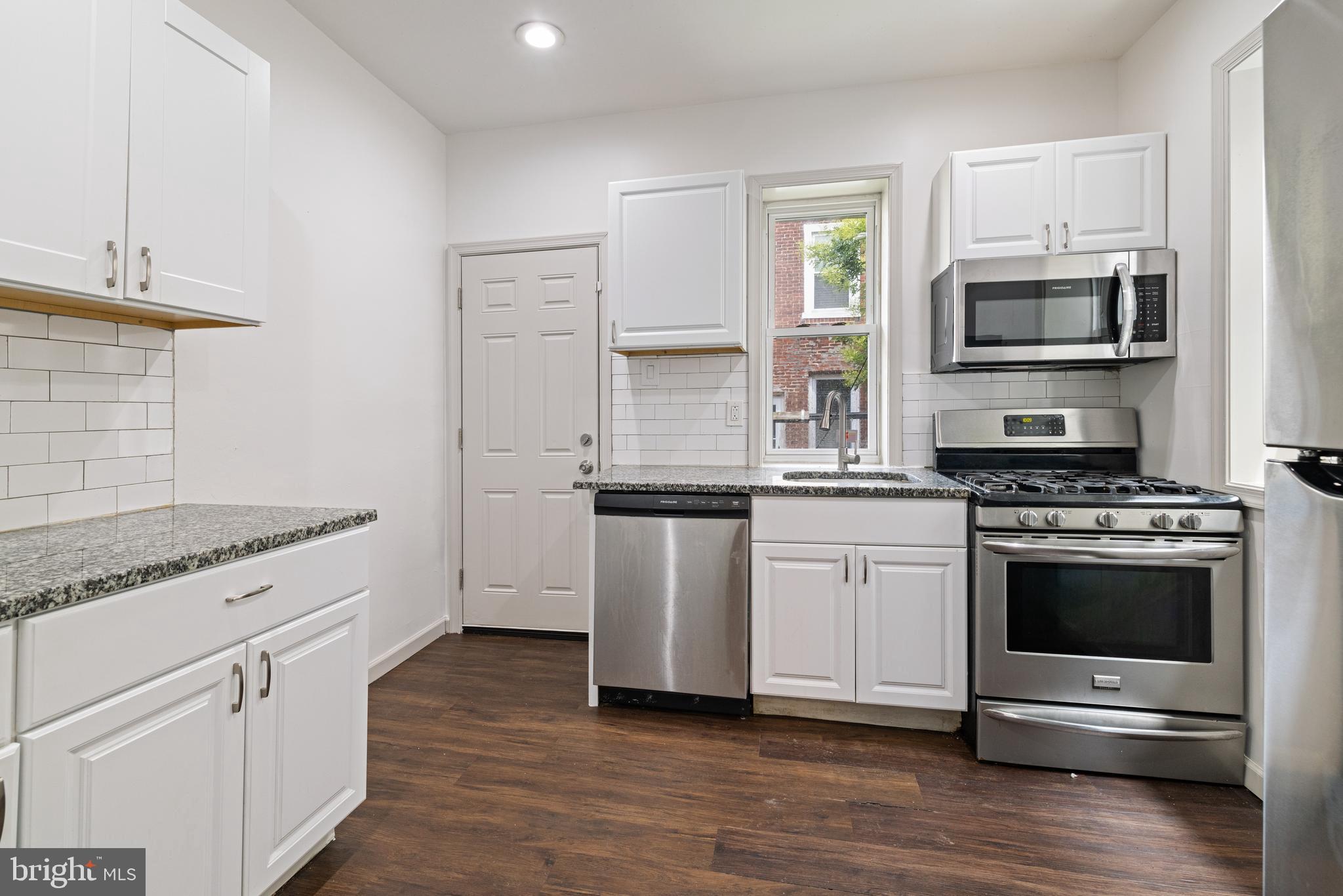 5551 Addison Street Philadelphia, PA 19143 - Photo 9 of 21 a kitchen with stainless steel appliances granite countertop a stove and a refrigerator
