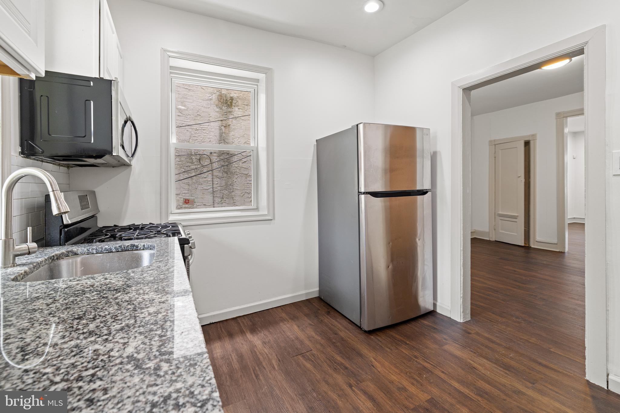 5551 Addison Street Philadelphia, PA 19143 - Photo 10 of 21 a kitchen with granite countertop a refrigerator and a sink