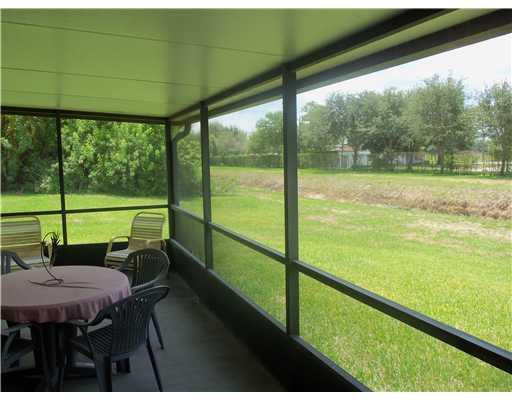 20973 Boca Ridge Drive West Boca Raton, FL 33428 - Photo 11 of 16 a view of a chairs and table in patio with a yard