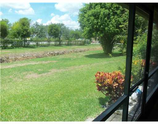 20973 Boca Ridge Drive West Boca Raton, FL 33428 - Photo 13 of 16 a yard with lots of green space and trees in the background