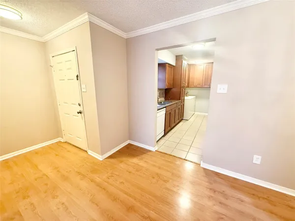 a view of an empty room with wooden floor and a fireplace