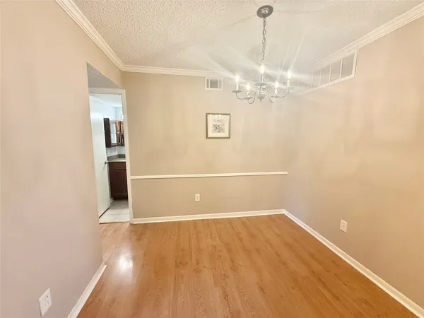 a view of an empty room with a window and kitchen view