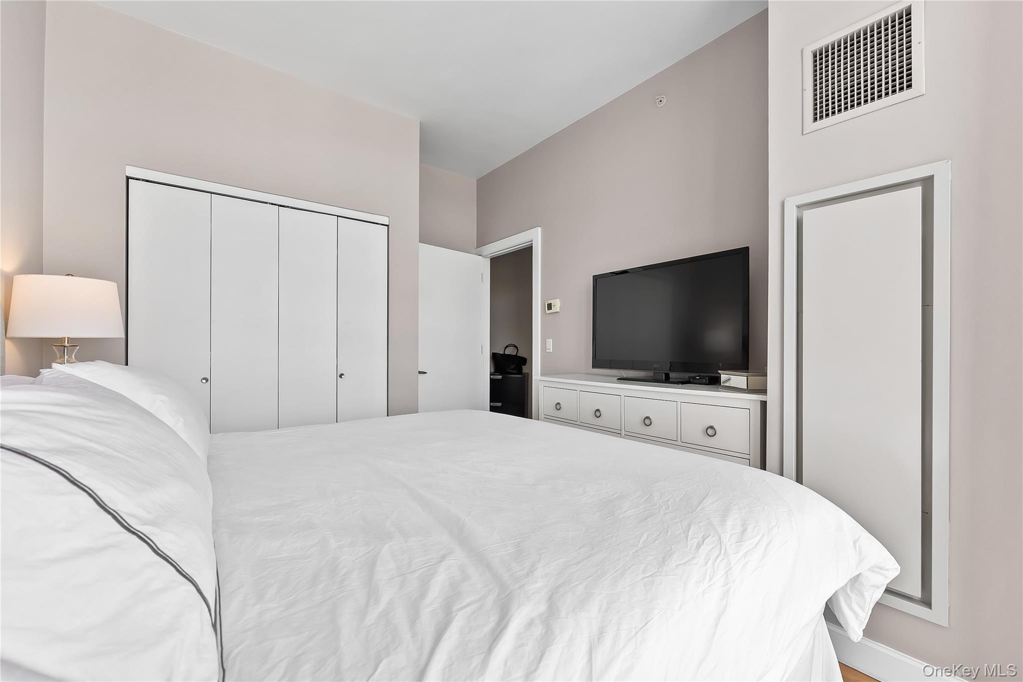 11-24 31st Avenue, Unit 12A Queens, NY 11106 - Photo 17 of 36 a bedroom with a bed and a flat screen tv