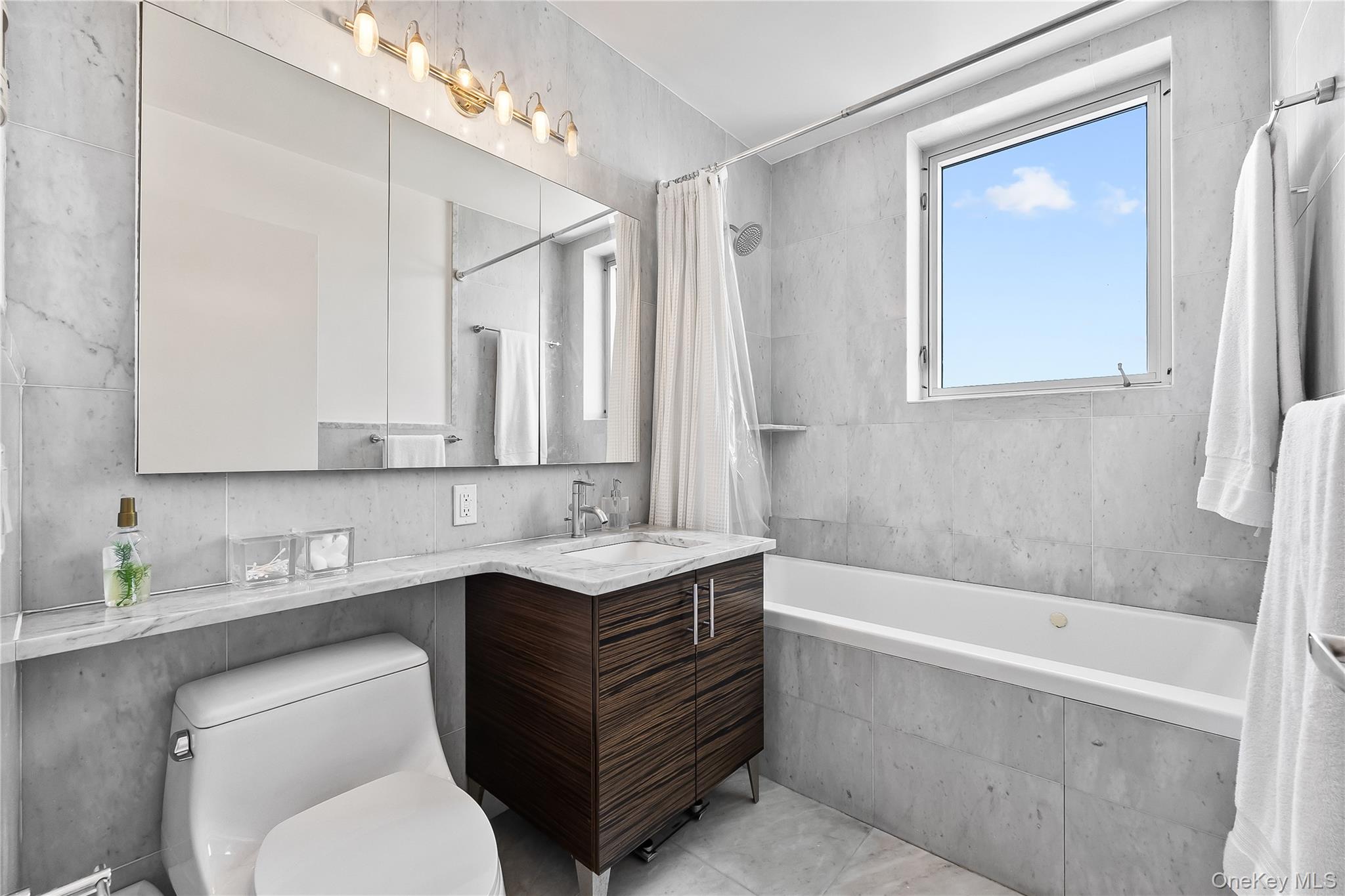 11-24 31st Avenue, Unit 12A Queens, NY 11106 - Photo 21 of 36 a bathroom with a sink a toilet and bathtub