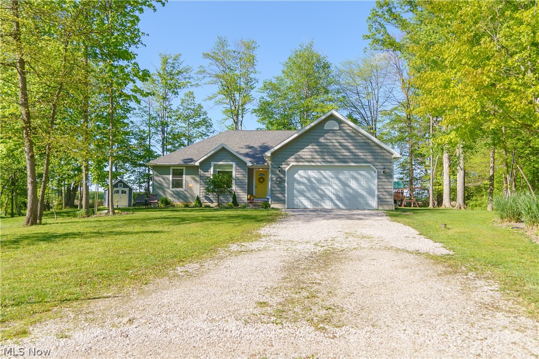 Single story home featuring a garage and a front lawn