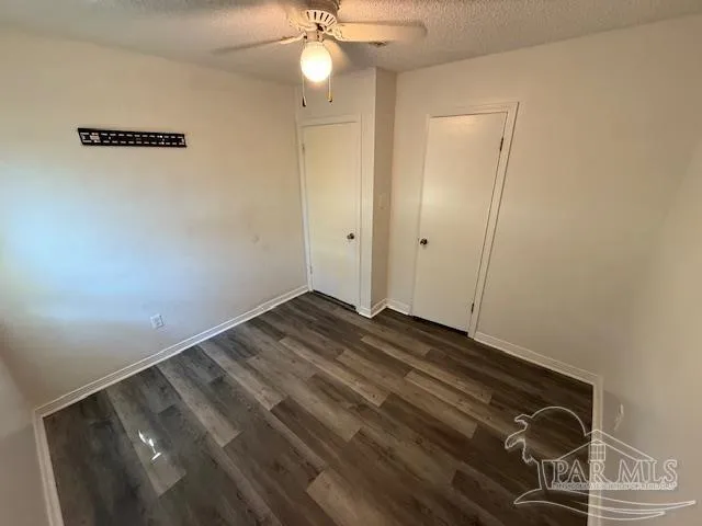 a view of a room with wooden floor and fan