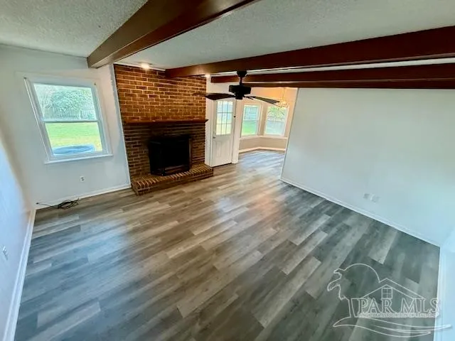 a view of a room with wooden floor and a fireplace