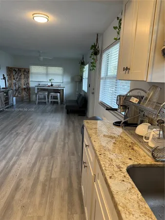 a view of a kitchen with a sink cabinets and wooden floor