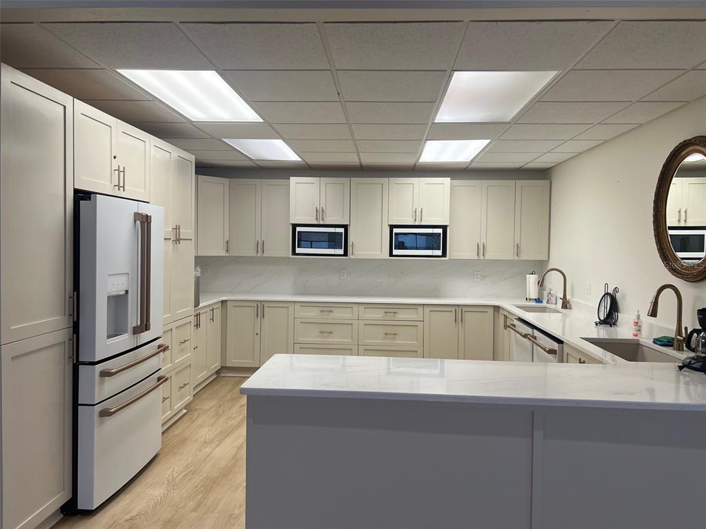 634 Edgewater Drive, Unit 447 Dunedin, FL 34698 - Photo 40 of 53 a kitchen with stainless steel appliances a sink a refrigerator a counter space and cabinets