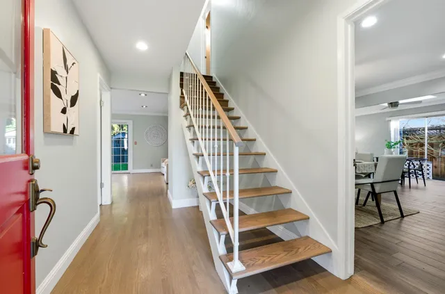 an entryway with a dining room and wooden floor