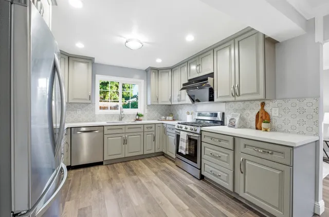 a kitchen with a refrigerator stove top oven and sink