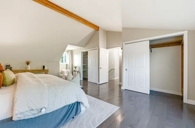 a spacious bedroom with a bed and wooden floor