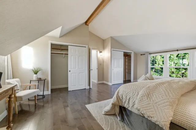 a spacious bedroom with a bed and wooden floor