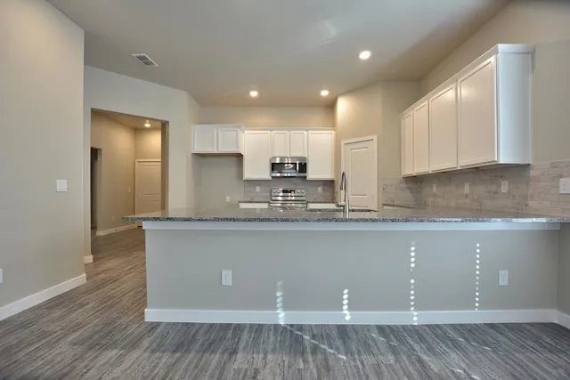 a kitchen with granite countertop a sink and cabinets
