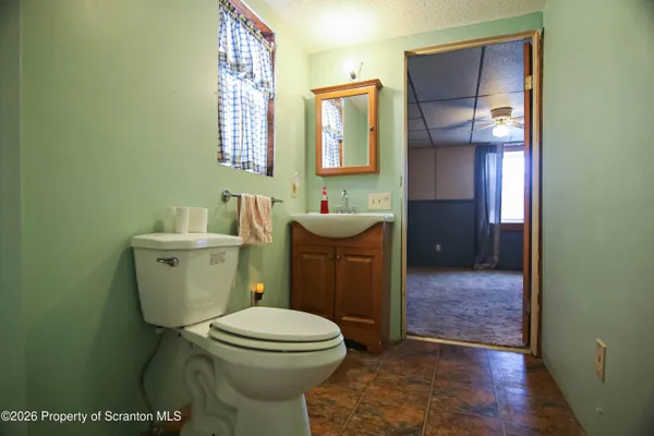 a bathroom with a toilet a sink and mirror