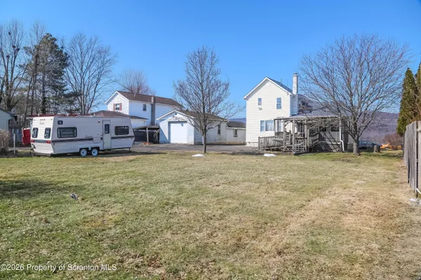a front view of a house with a yard covered with trees