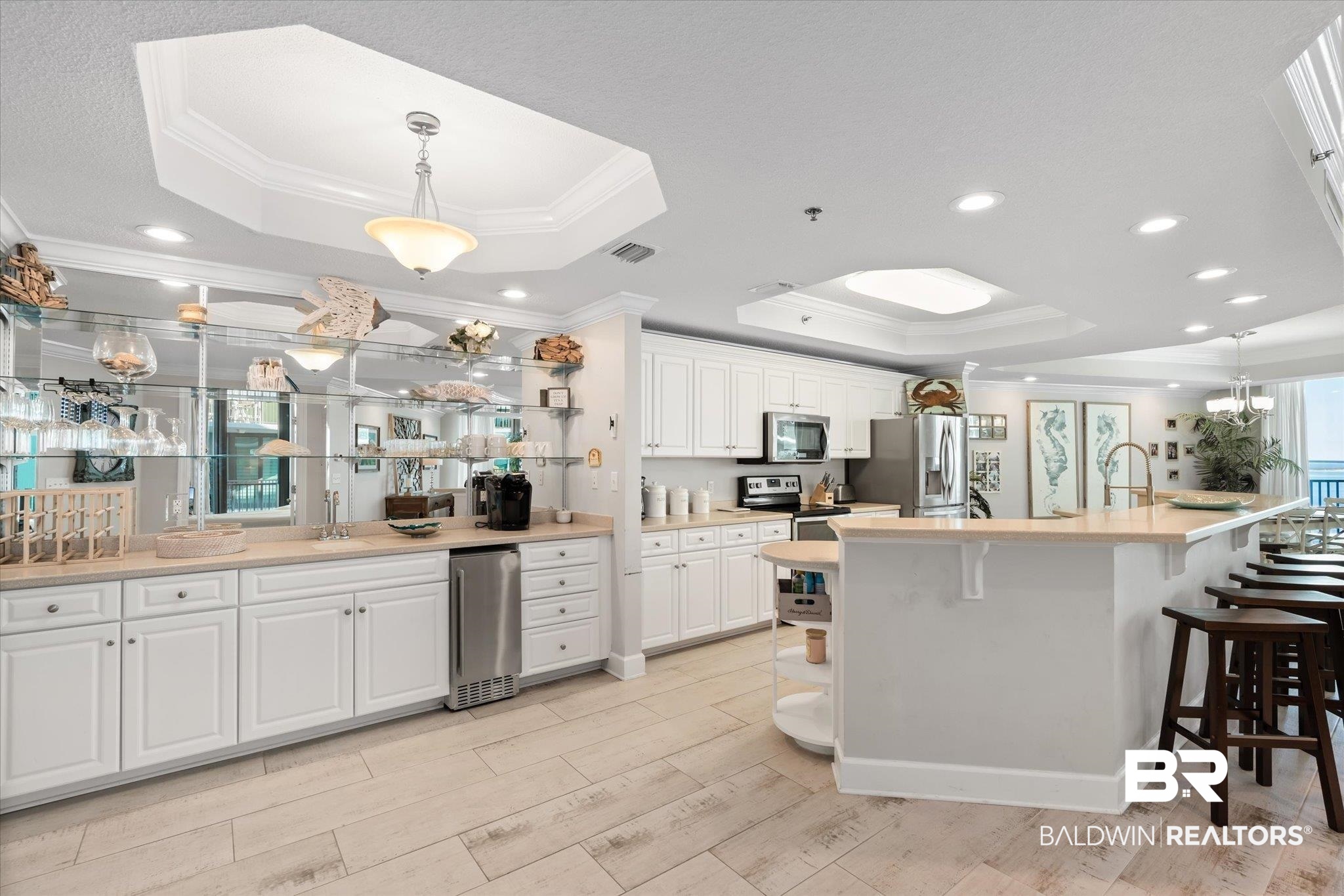 27582 Canal Road, Unit 2611 Orange Beach, AL 36561 - Photo 7 of 37 Kitchen featuring white cabinets, appliances with stainless steel finishes, a raised ceiling, and a large island with sink