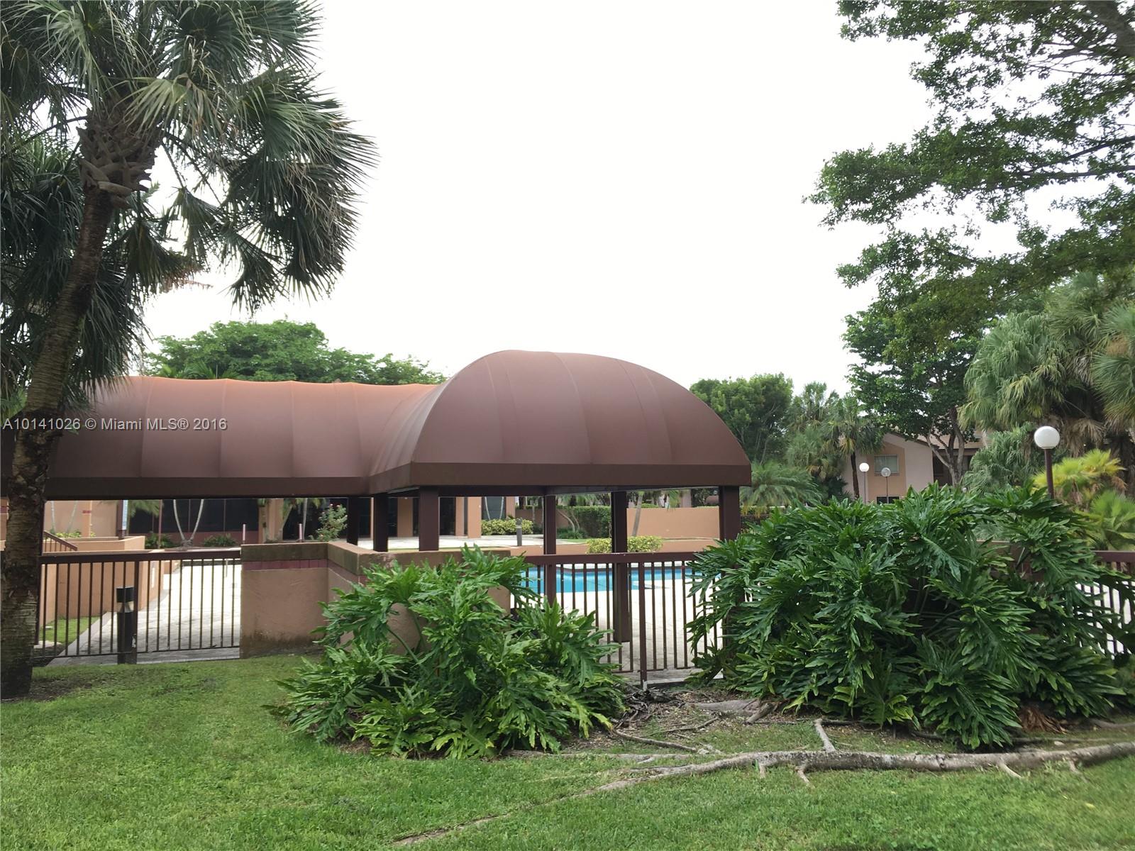 13946 Southwest 90th Terrace, Unit 13946 Miami, FL 33186 - Photo 14 of 16 a front view of house with yard and trees all around