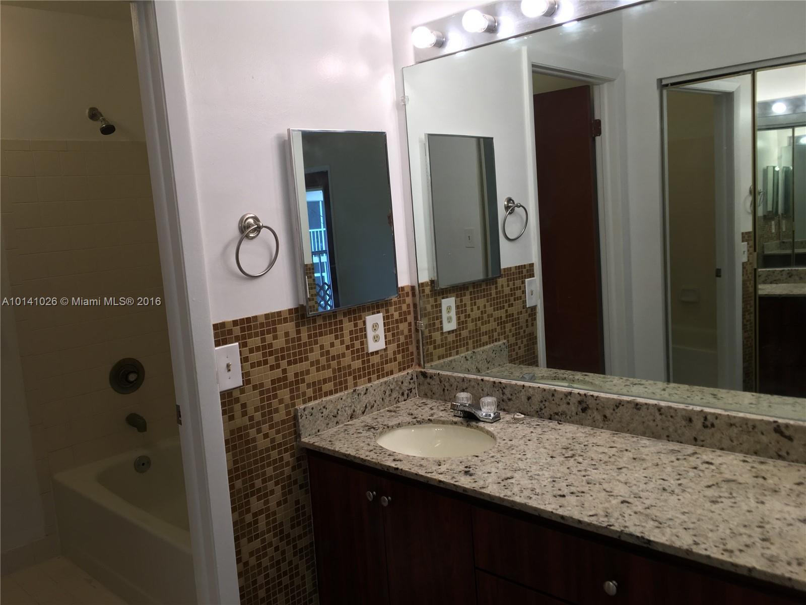 13946 Southwest 90th Terrace, Unit 13946 Miami, FL 33186 - Photo 4 of 16 a bathroom with a granite countertop sink and a bathtub
