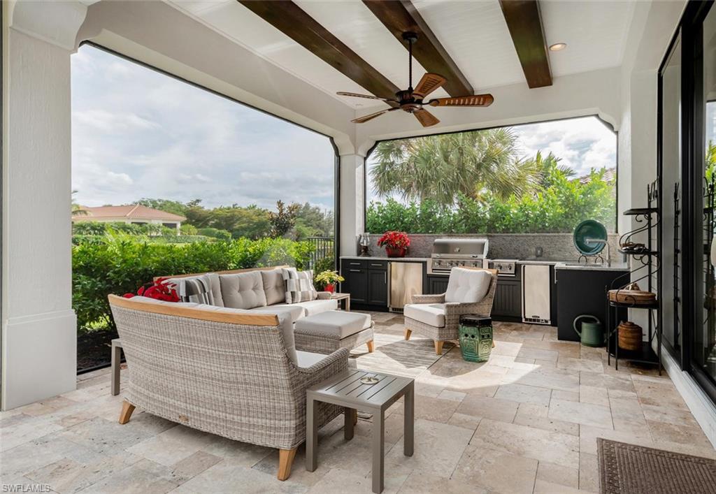 2220 Residence Circle Naples, FL 34105 - Photo 15 of 30 a view of a patio with a table chairs and a floor to ceiling window