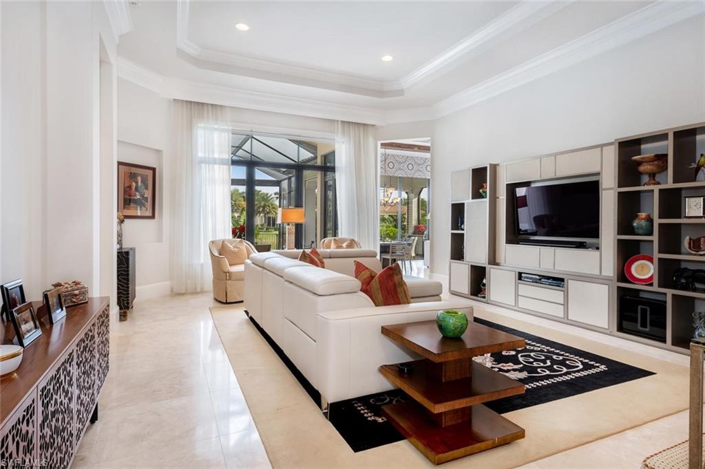 2220 Residence Circle Naples, FL 34105 - Photo 17 of 30 a living room with furniture a flat screen tv and a window