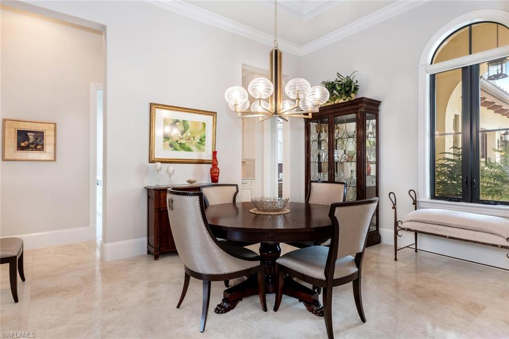 2220 Residence Circle Naples, FL 34105 - Photo 19 of 30 a dining room with furniture a large window and a chandelier