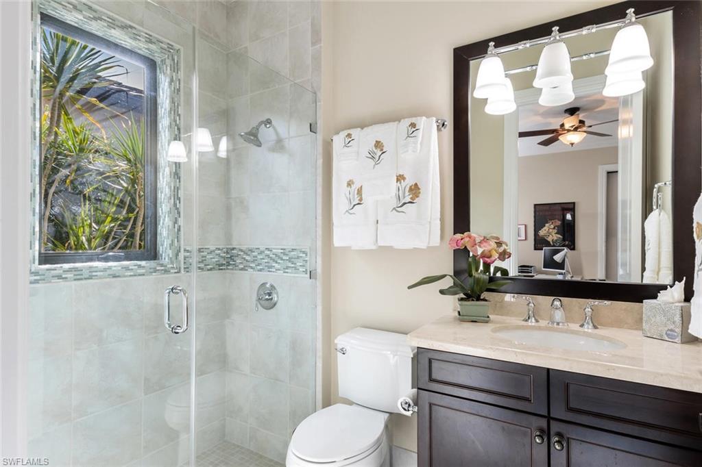 2220 Residence Circle Naples, FL 34105 - Photo 25 of 30 a bathroom with a granite countertop sink toilet a mirror and shower