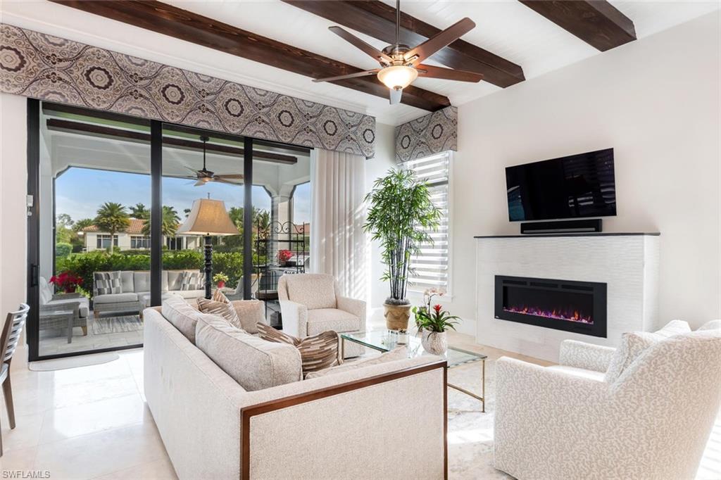 2220 Residence Circle Naples, FL 34105 - Photo 6 of 30 a living room with furniture a fireplace and a flat screen tv