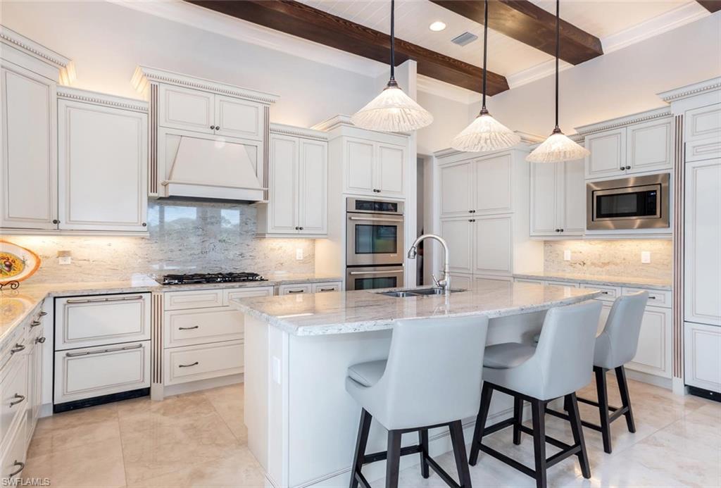 2220 Residence Circle Naples, FL 34105 - Photo 7 of 30 a kitchen with stainless steel appliances granite countertop a sink a stove a dining table and chairs