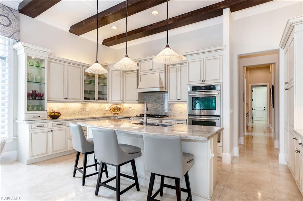 2220 Residence Circle Naples, FL 34105 - Photo 8 of 30 a kitchen with stainless steel appliances kitchen island granite countertop a stove a sink and a refrigerator