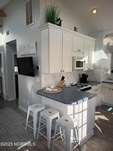 a kitchen with granite countertop a sink stove and refrigerator