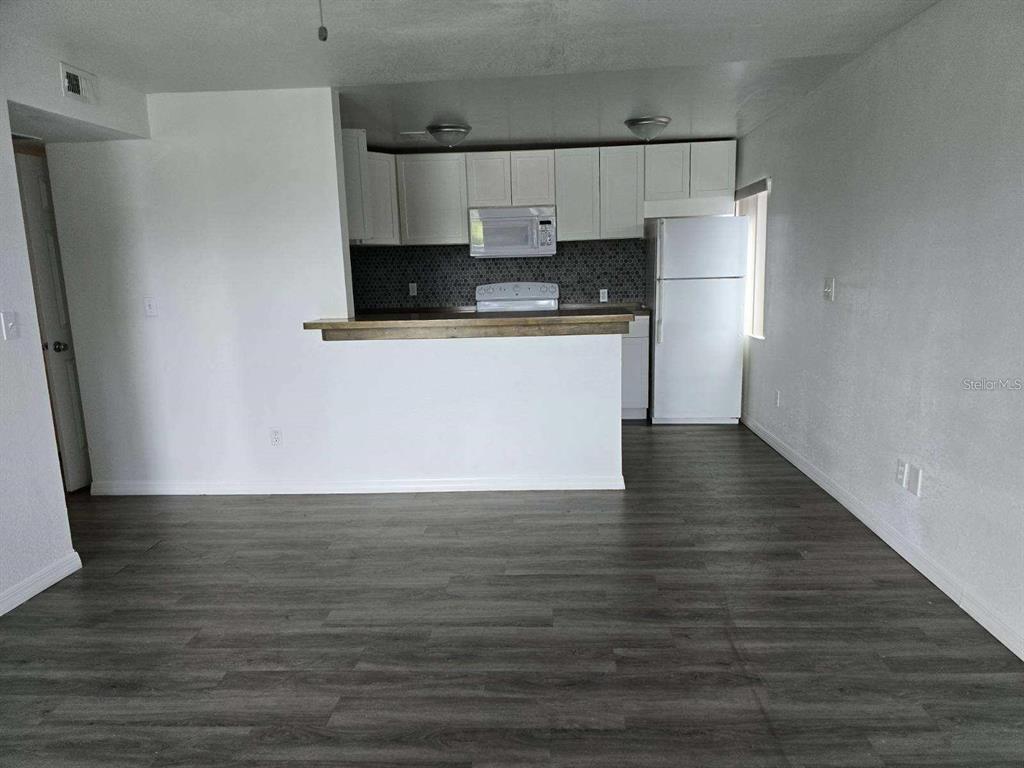 800 North Fiske Boulevard, Unit 714 Cocoa, FL 32922 - Photo 2 of 7 a view of kitchen refrigerator microwave and cabinets