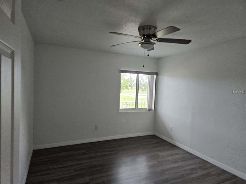 800 North Fiske Boulevard, Unit 714 Cocoa, FL 32922 - Photo 6 of 7 an empty room with wooden floor fan and windows