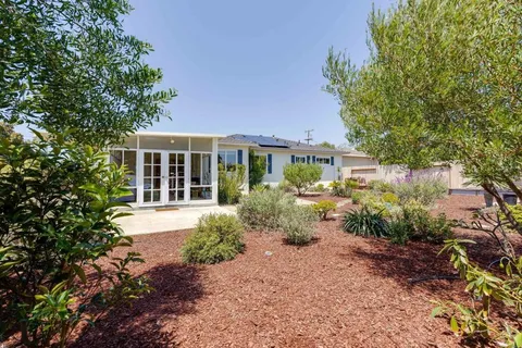a front view of a house with garden and porch