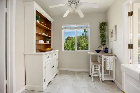 a kitchen with white cabinets and sink