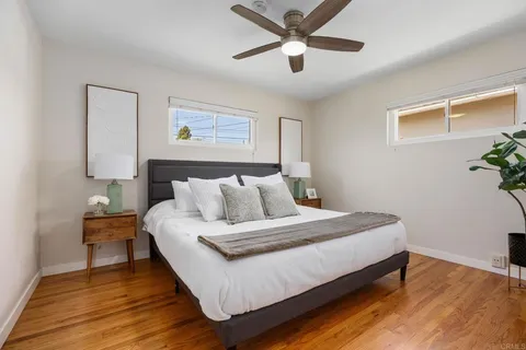 a large bedroom with a bed and wooden floor