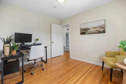 a view of a workspace with furniture and wooden floor