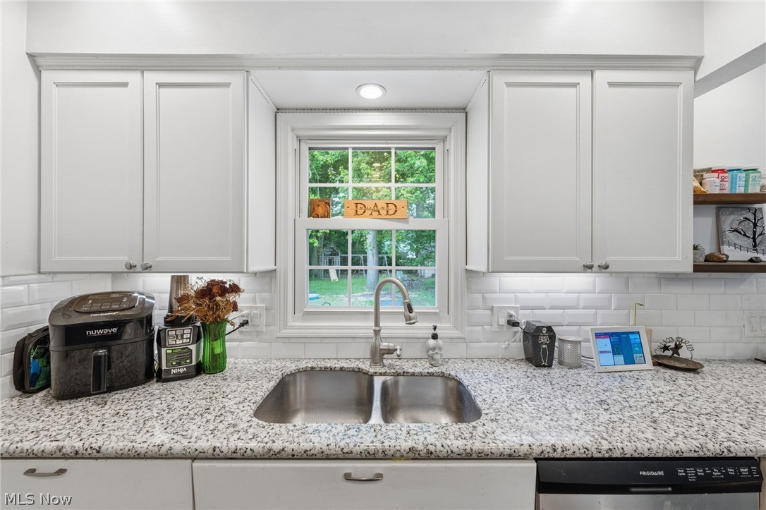 6472 Southgrove Road Mentor, OH 44060 - Photo 15 of 37 Kitchen featuring a double basin stainless steel sink, light granite-style countertops, white shaker-style cabinetry, and a white subway tile backsplash