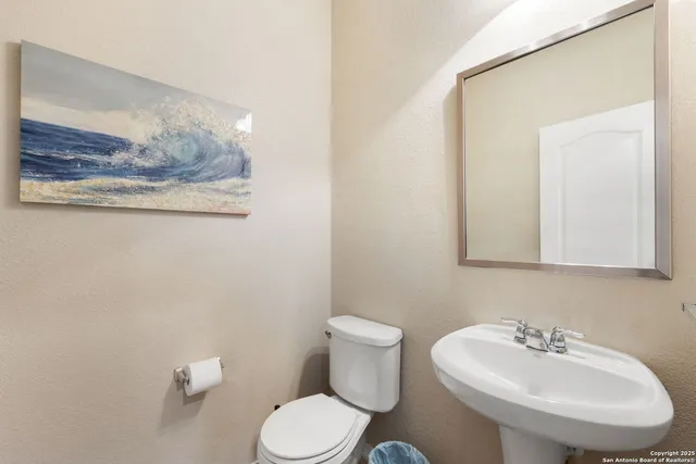 a bathroom with a sink mirror and toilet