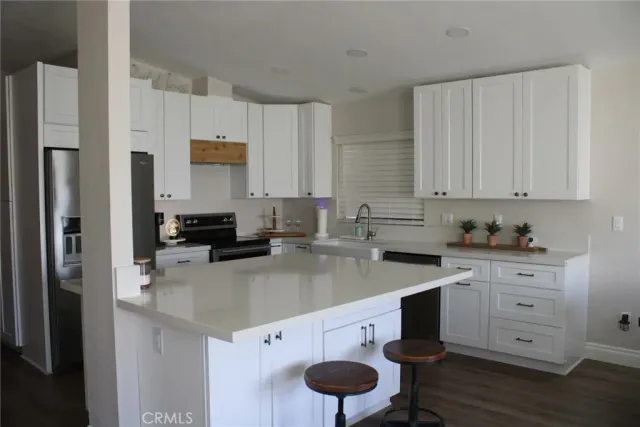 a kitchen with stainless steel appliances granite countertop a sink a stove and cabinets