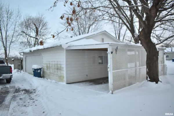 a view of a white house with a large tree