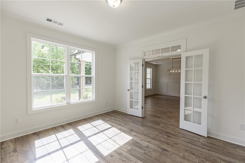 1210 Austin Road Winder, GA 30680 - Photo 8 of 56 an empty room with wooden floor and windows