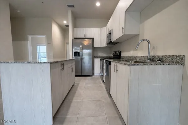 a kitchen with stainless steel appliances granite countertop a sink and a stove top oven