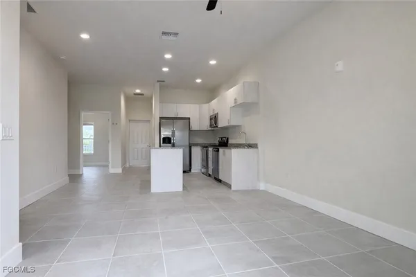a view of kitchen with refrigerator and cabinets