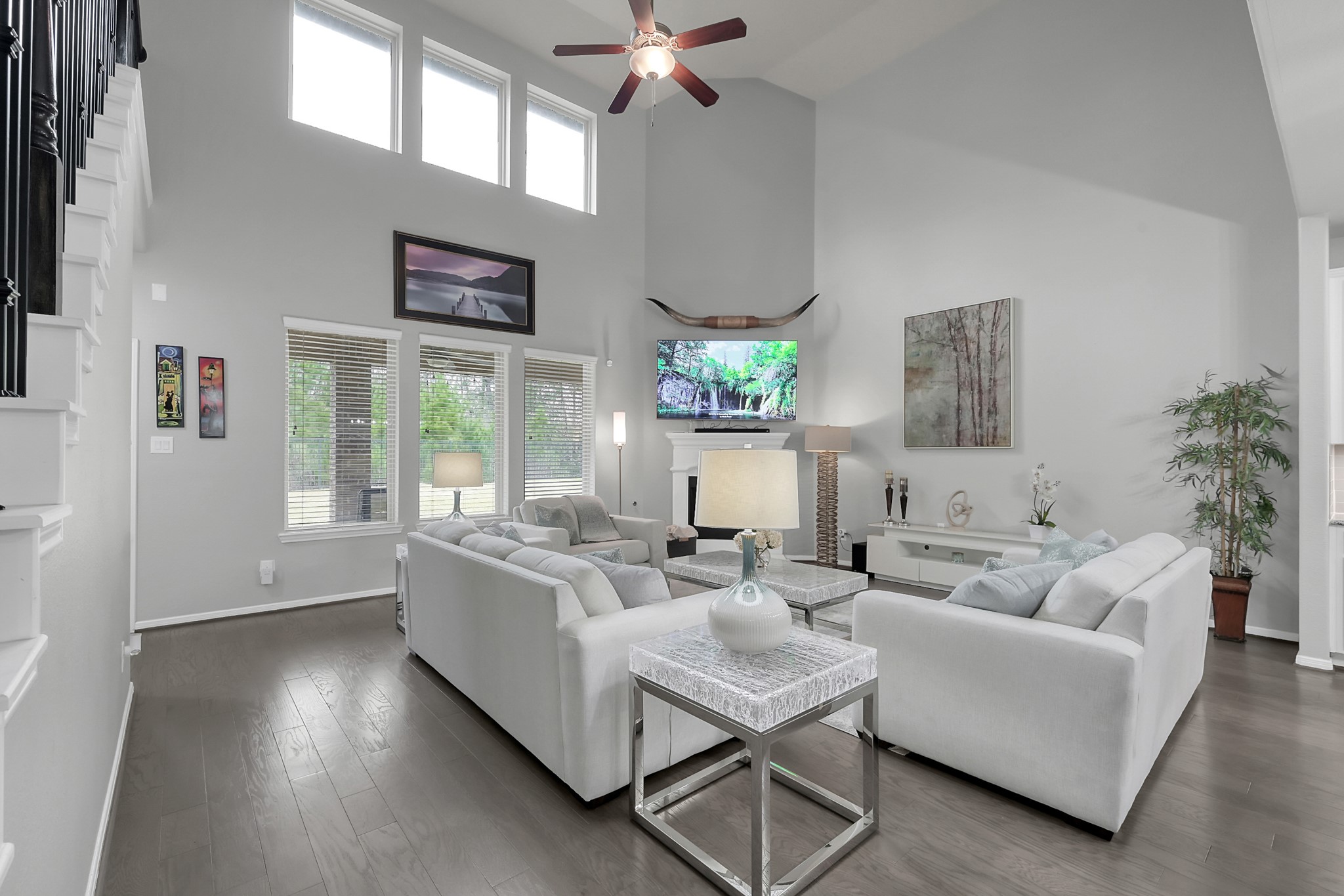 24542 Grayson Falls Lane Spring, TX 77389 - Photo 15 of 48 This spacious living room features high ceilings and large windows for abundant natural light. With modern decor, a cozy fireplace, and elegant wood floors, it's perfect for relaxation and entertainment.