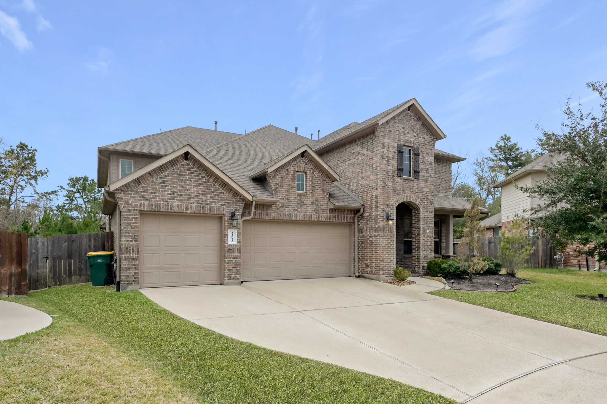 24542 Grayson Falls Lane Spring, TX 77389 - Photo 2 of 48 This is a two-story brick home with a spacious driveway and three-car garage. It features a landscaped front yard and is situated in a wonderful cul-de-sac with trees and neighboring homes.