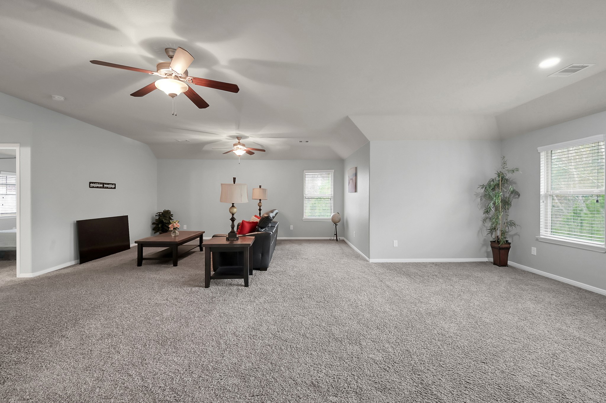 24542 Grayson Falls Lane Spring, TX 77389 - Photo 27 of 48 This spacious living area features plush carpeting, neutral walls, and ample natural light from multiple windows. It includes ceiling fans for comfort, a cozy seating area, and a modern, open layout perfect for relaxation or entertaining. Great flex space for a man-cave, office and 2nd living room or and entertainment room!